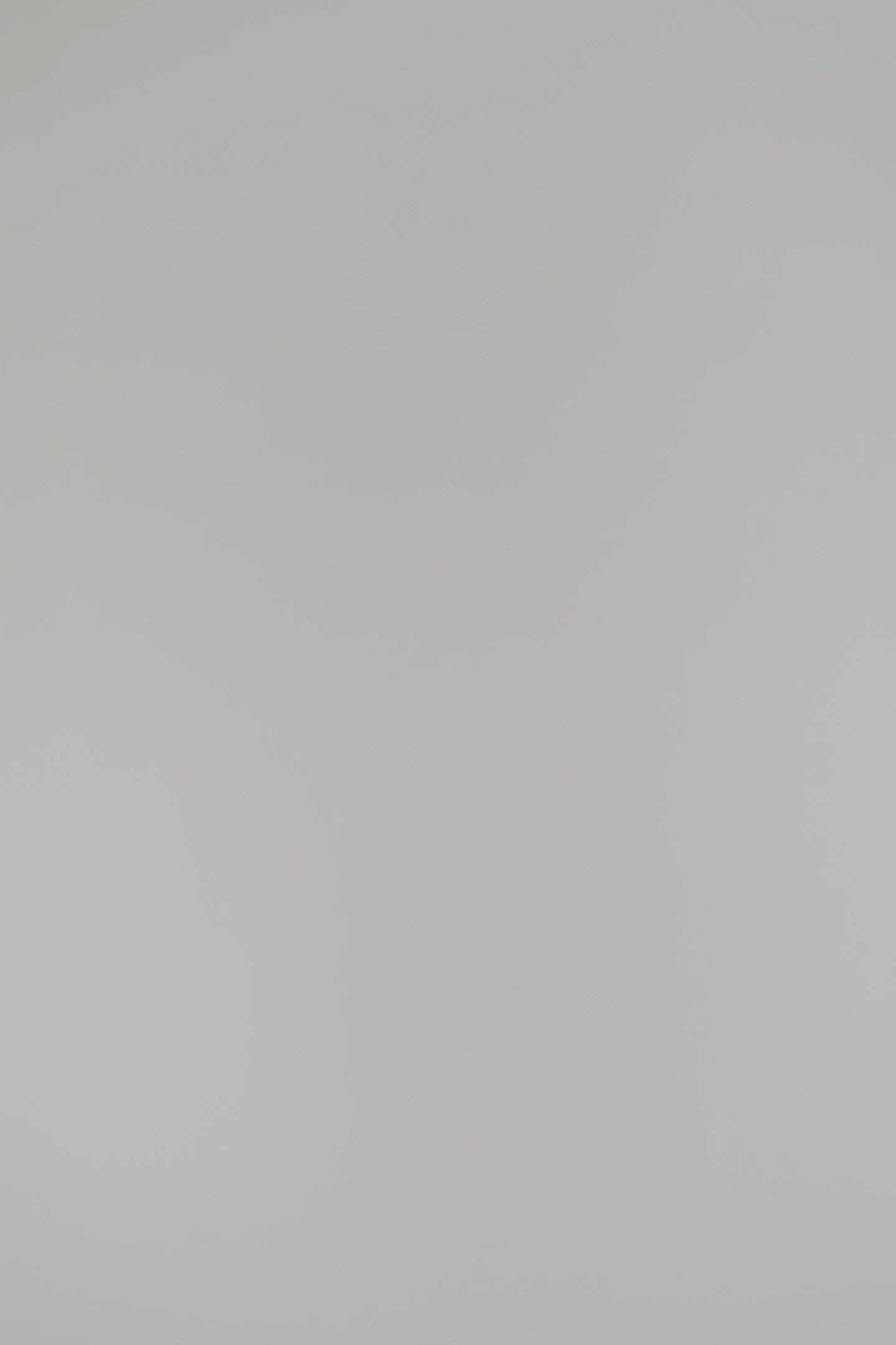 Woman wearing a cream sleeveless blouse on a white background