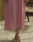Woman modeling a silk skirt in peak that is pleated in a room