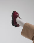 Woman modeling European shoes with tan  pants on a white backdrop