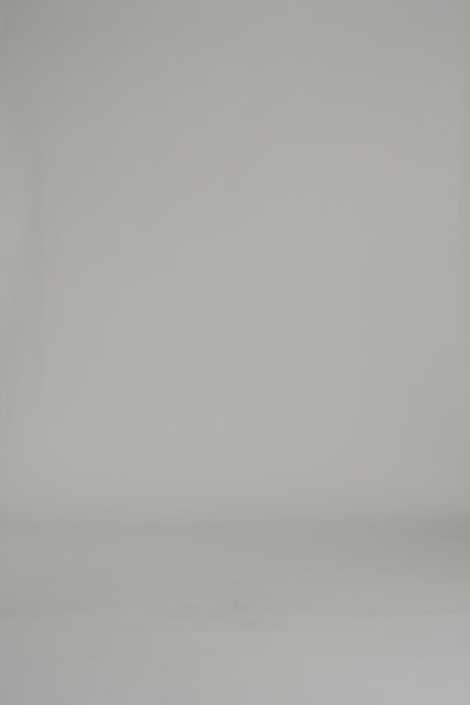 woman modeling black and white floral mini dress on a white backdrop