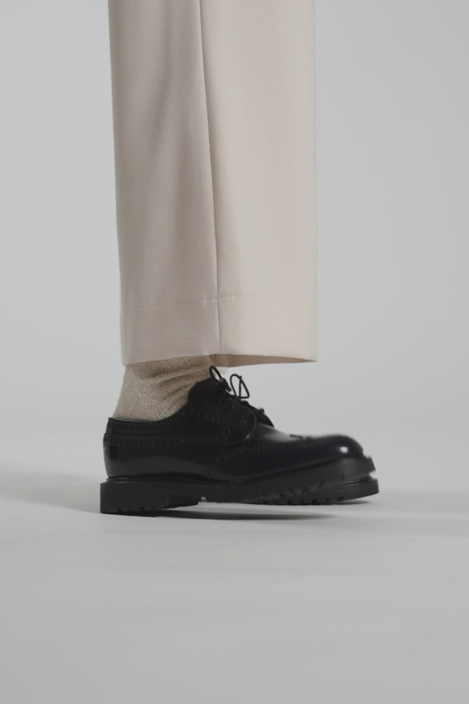 Close up video of a navy shoe tapping the white ground