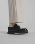 Close up video of a navy shoe tapping the white ground
