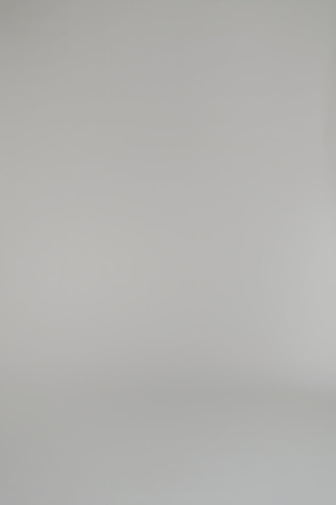 woman modeling cream blouse with gold shorts