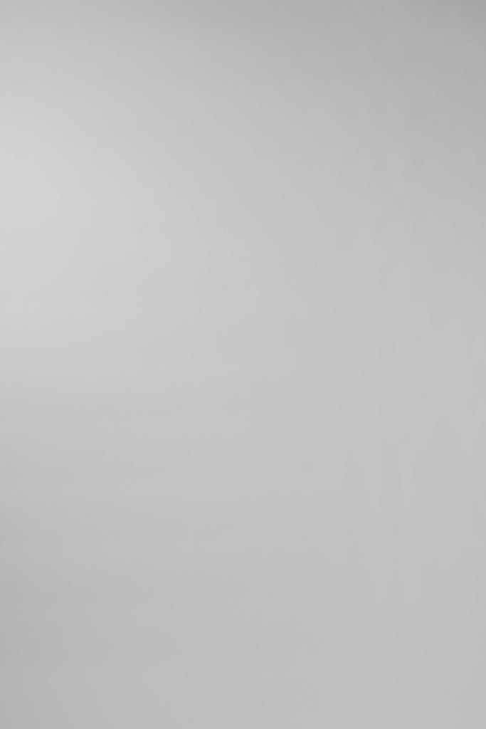 Video of woman walking across a white backdrop wearing a sleeveless pink silk shell