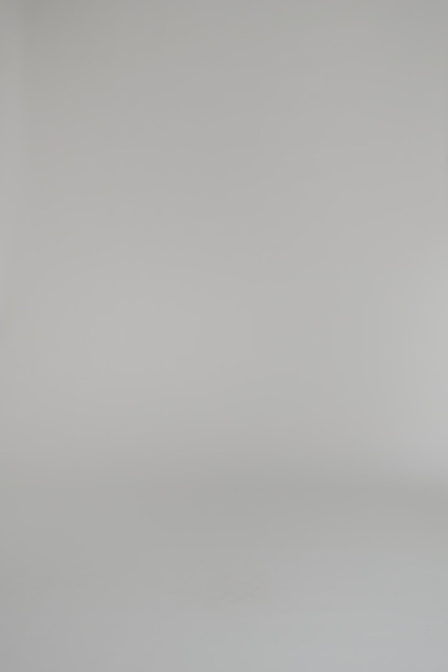 woman wearing a black and white patterned wrap and black heels on a white backdrop