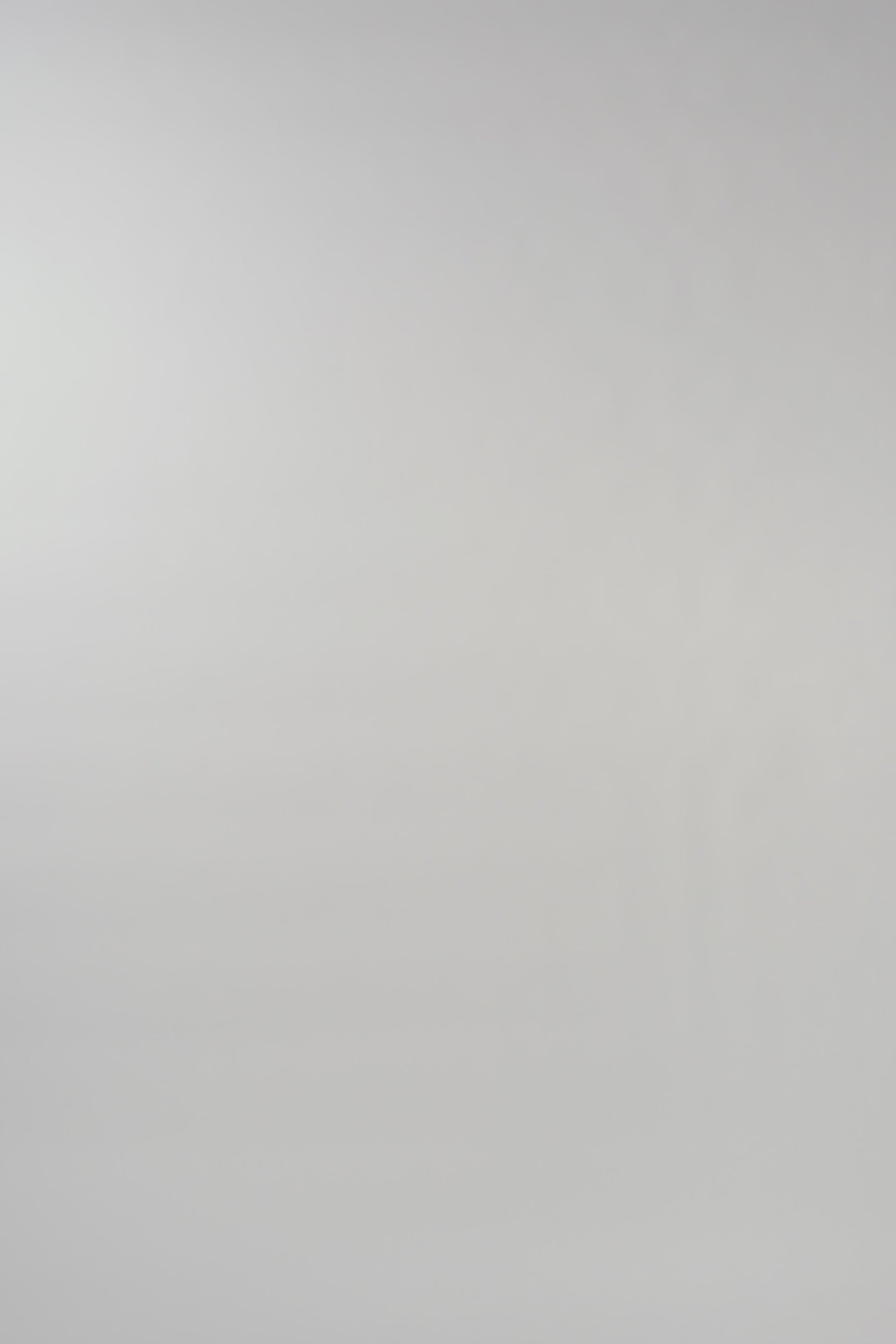 Video of woman walking across a white backdrop wearing a long sleeve blue silk crewneck