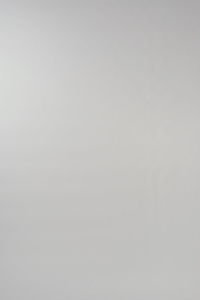 Video of woman walking across a white backdrop wearing a long sleeve blue silk crewneck