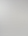 Video of woman walking across a white backdrop wearing a long sleeve blue silk crewneck