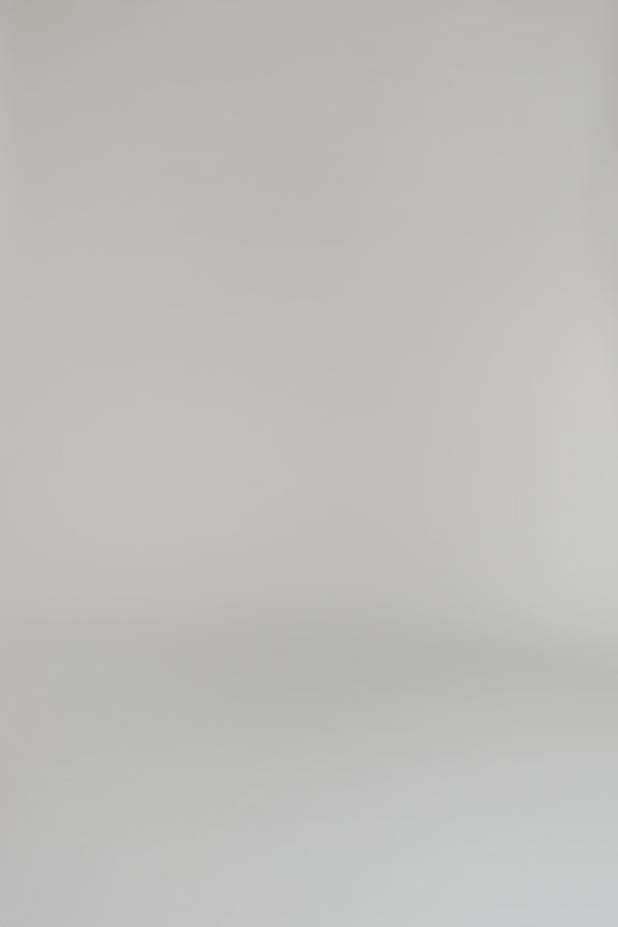 Woman wearing white and navy silk shirt dress with long sleeves