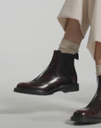Close up video of burgundy boots on a white background
