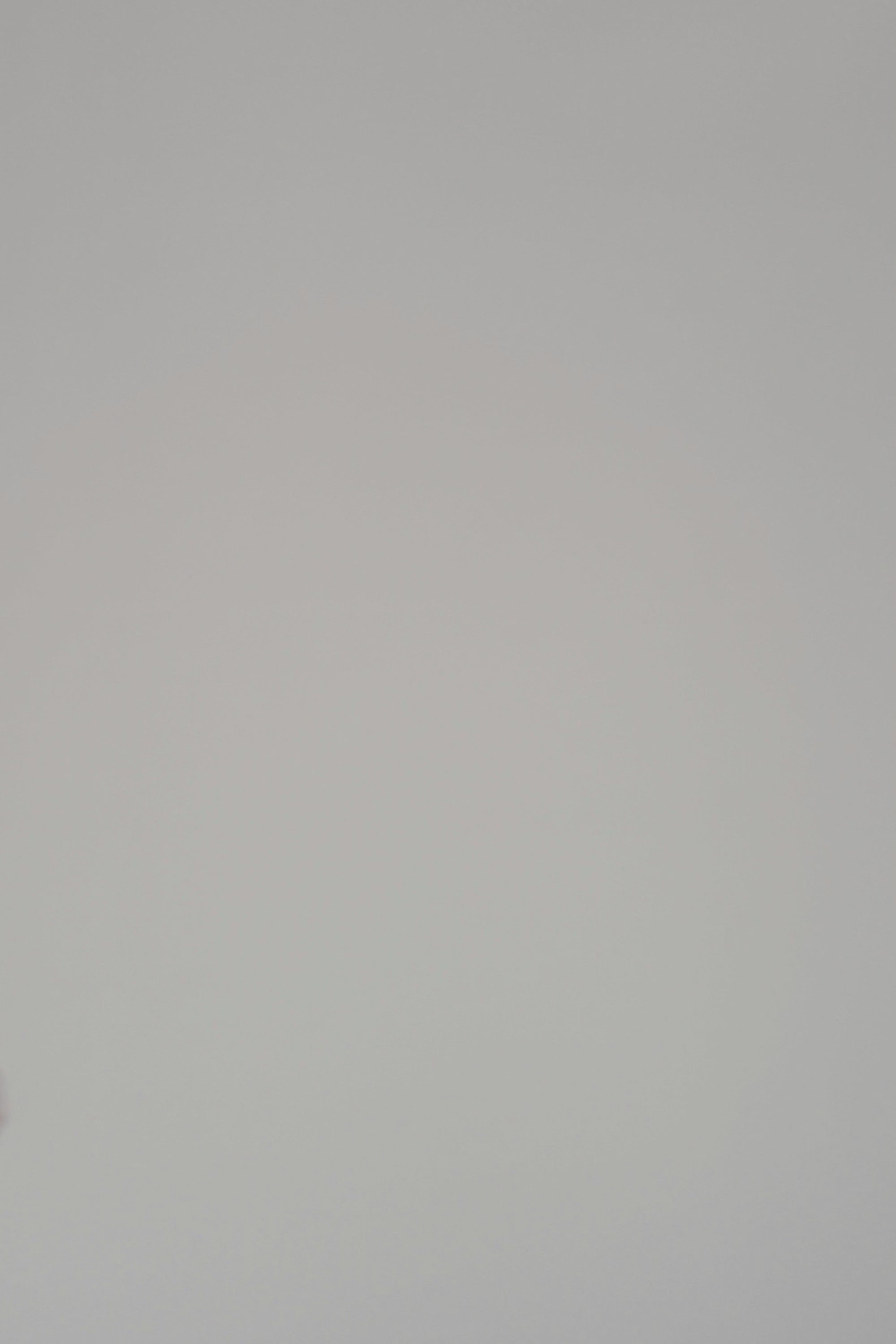 Woman modeling a long sleeve sweater on a plain backdrop