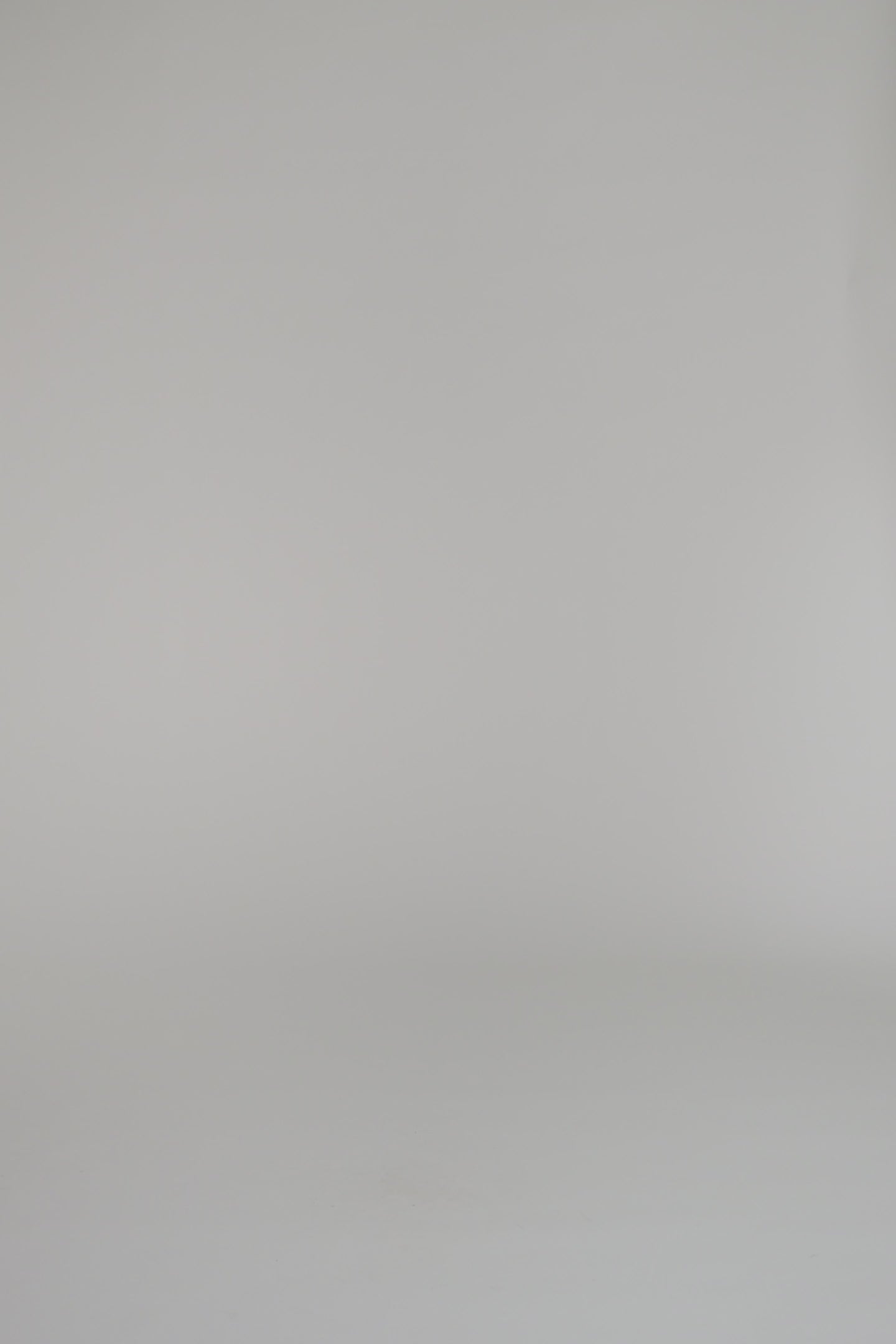 woman modeling red cardigan in black heels with a white backdrop