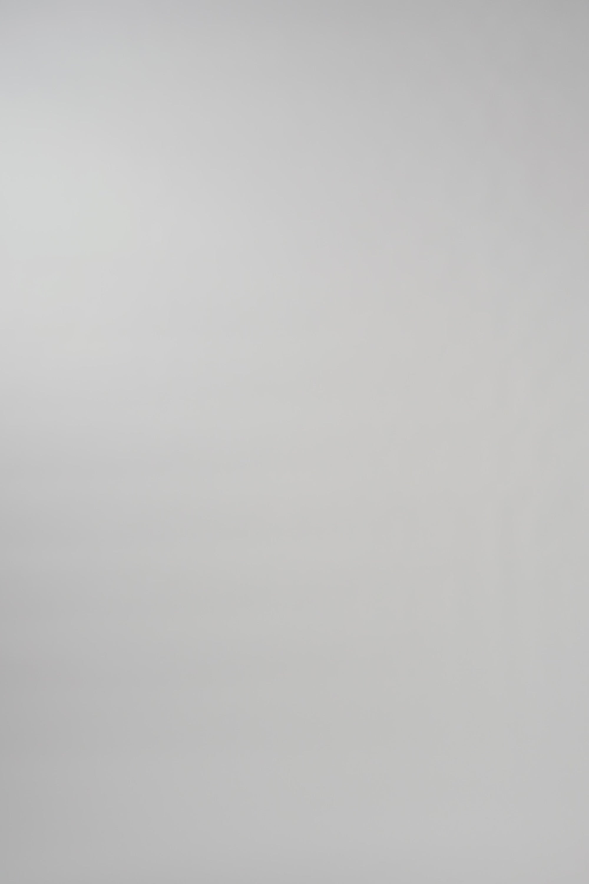 Video of woman walking across a white backdrop wearing a long sleeve pink silk crewneck