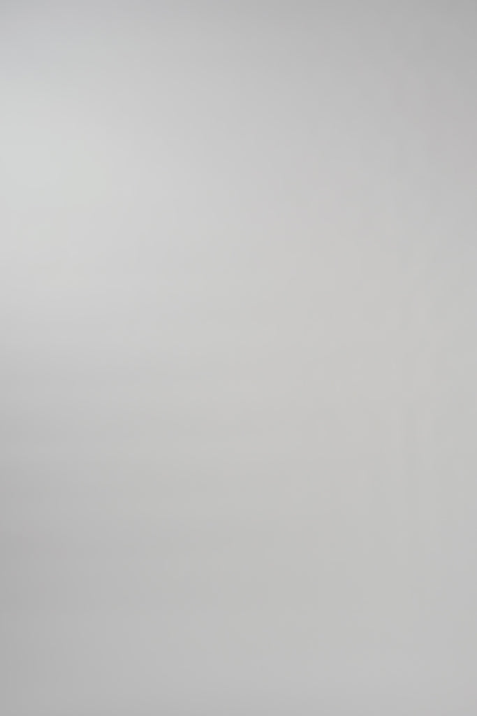 Video of woman walking across a white backdrop wearing a long sleeve pink silk crewneck