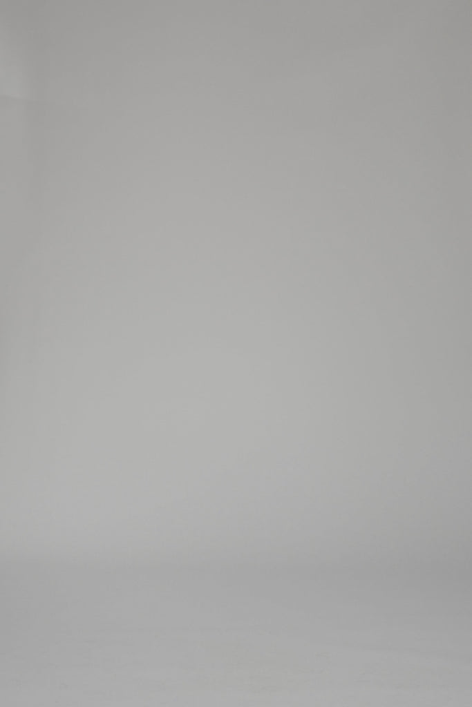 Woman wearing a mutli-color striped long sleeve dress on a plain backdrop