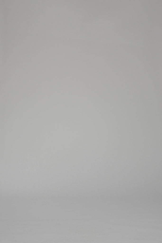 Woman modeling a green and white striped mid-length dress on a white backdrop