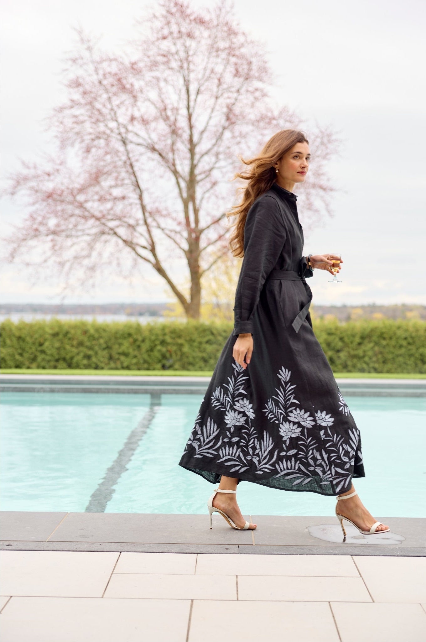 Woman wearing a black maxi dress with floral patterns outside on patio